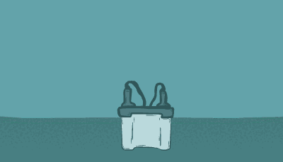 A scientist in blue goggles walks up to a counter and analyzes an item on a table